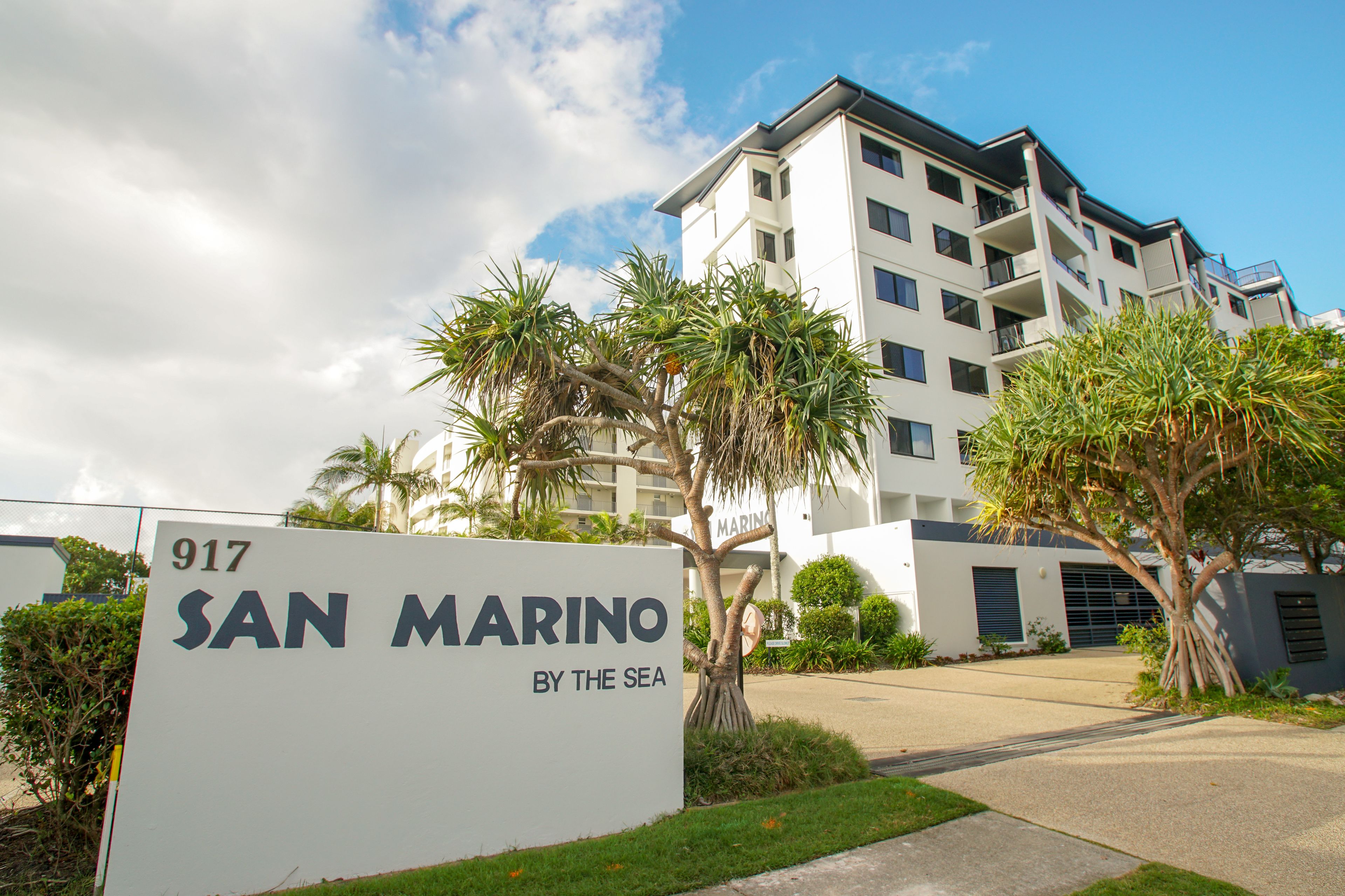 A multi-story building with a sign reading "SAN MARINO BY THE SEA".