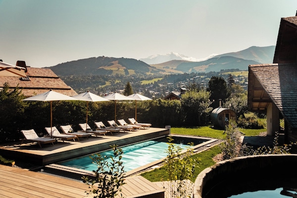 Een binnenzwembad, een buitenzwembad, ligstoelen bij het zwembad