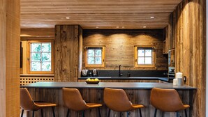 Un intérieur en bois avec un coin bar, deux fenêtres et un évier.