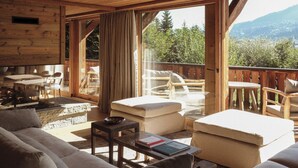 L’intérieur d’un chalet en bois chaleureux et accueillant, avec un canapé, des fauteuils et une table.