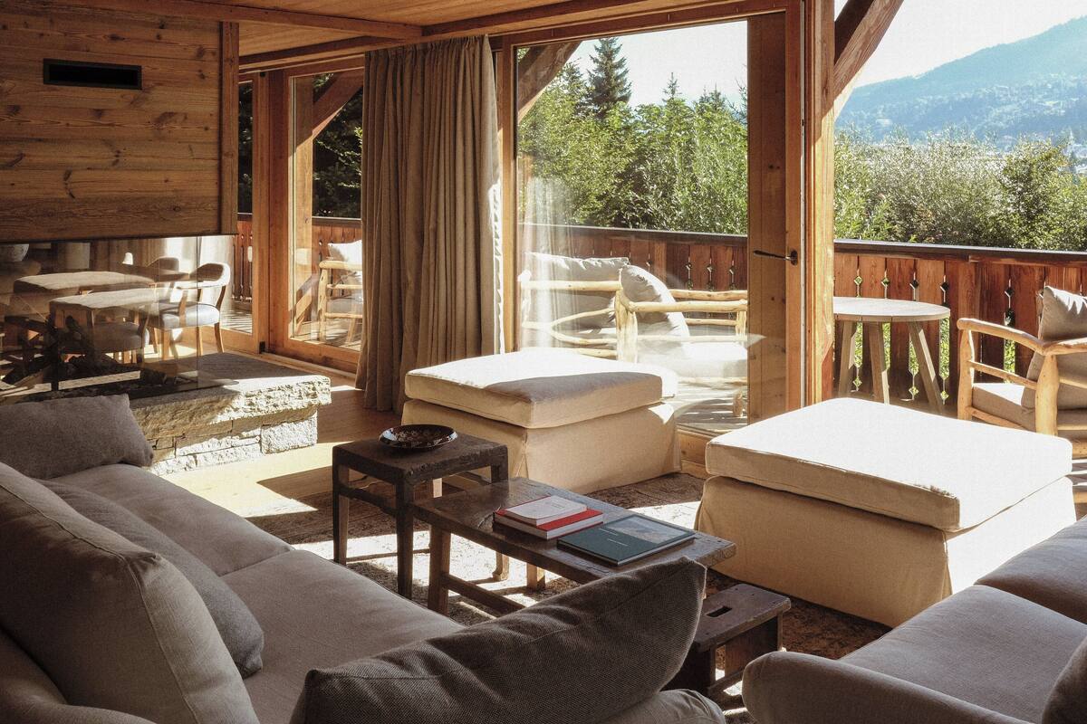 A cozy wooden cabin interior with a sofa, chairs, and a table.