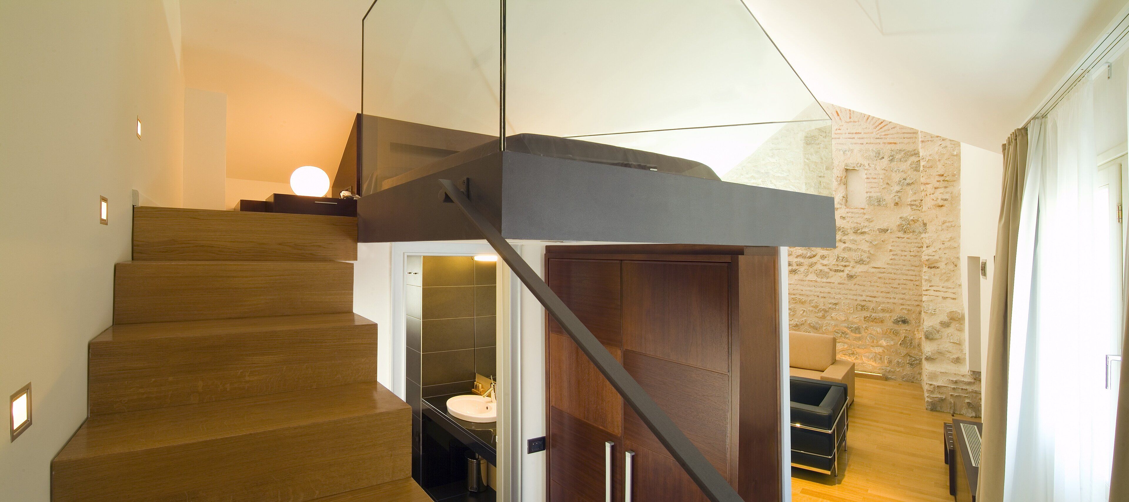 Un escalier moderne avec des marches en bois et une rampe en verre.