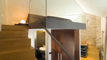 Un escalier moderne avec des marches en bois et une rampe en verre.