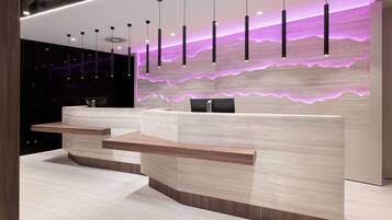 A modern reception desk with a light wood finish and a built-in counter.