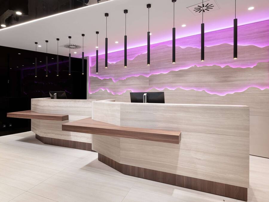 A modern reception desk with a light wood finish and a built-in counter.