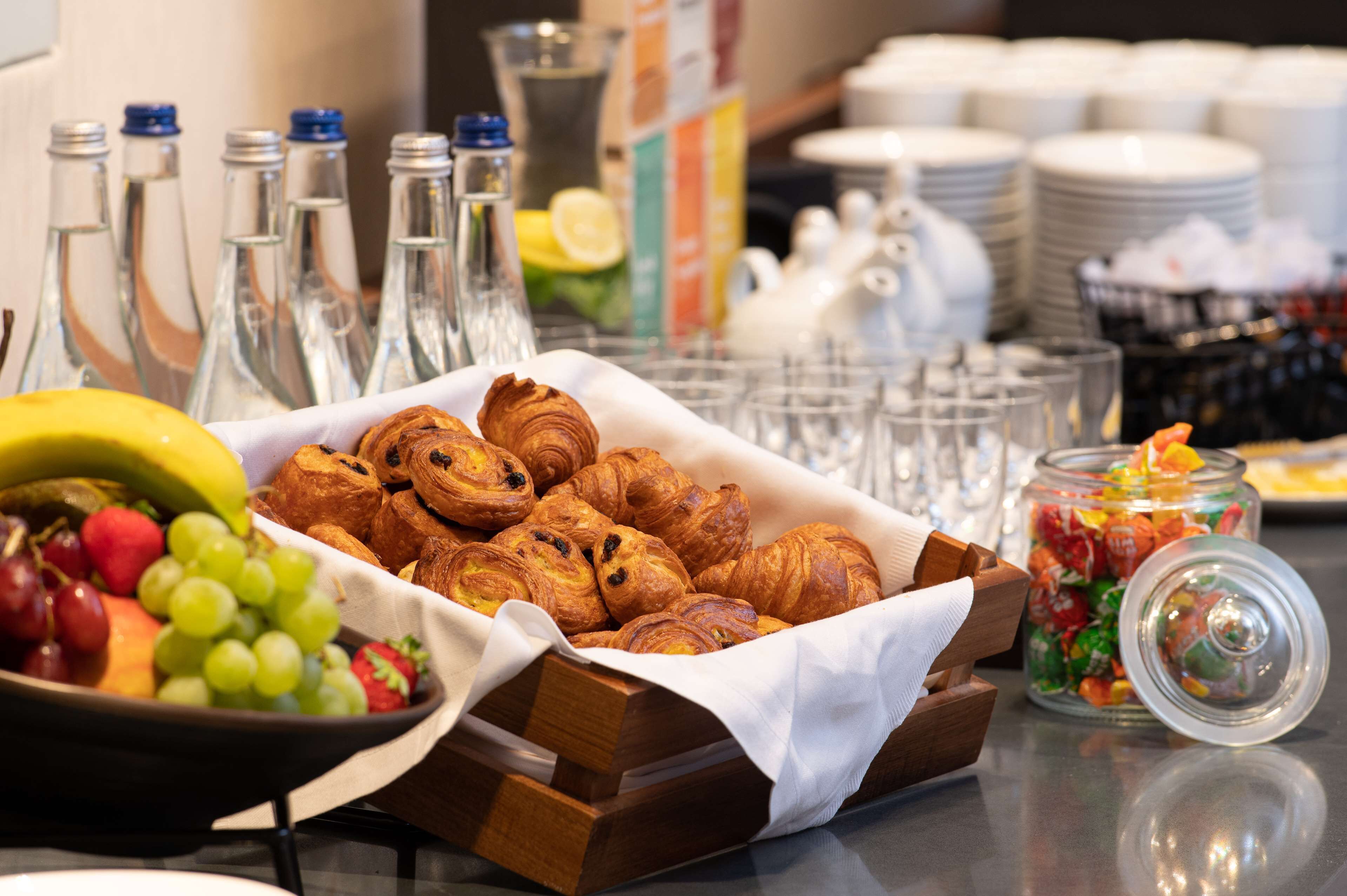 Un bufé de desayuno con pasteles, frutas y bebidas.