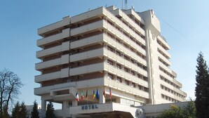 Un hotel de varios pisos con fachada plana y balcones en cada nivel, con un cartel que indica que es un hotel.