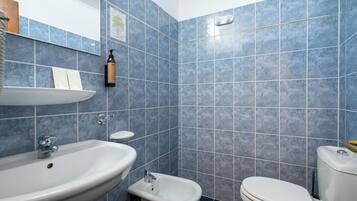 Un baño con lavamanos, bidé e inodoro.