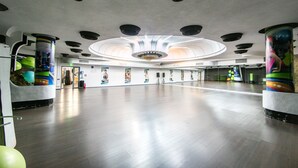 Un amplio espacio interior con techo alto, iluminación empotrada y una lámpara central de araña.