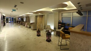 A hotel lobby with a modern design, featuring a reception desk, seating area with sofas and chairs, decorative lanterns, and a television screen. - Wes Hotel Izmit (Izmit)
