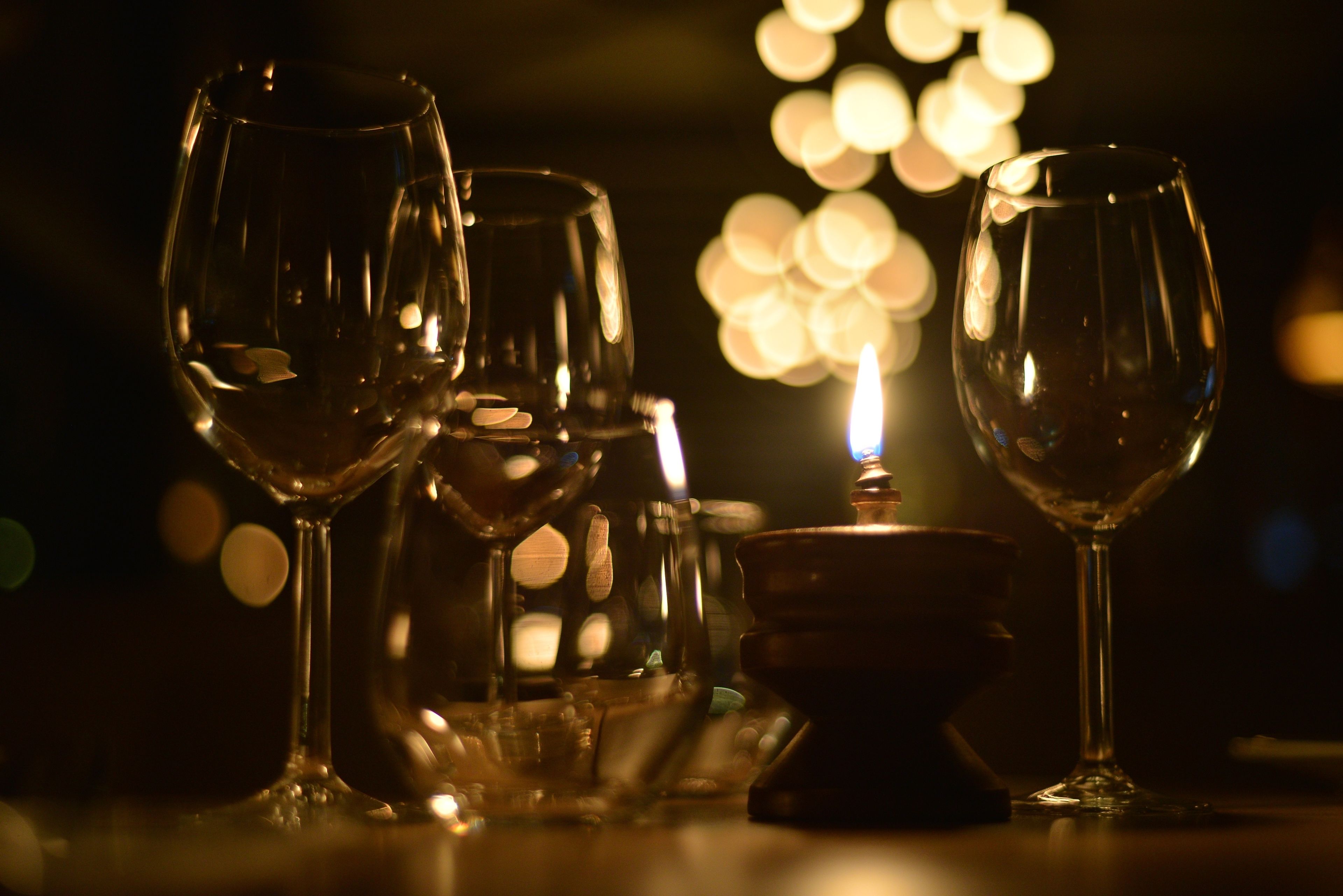 Un tavolo con diversi bicchieri da vino vuoti e una candela.