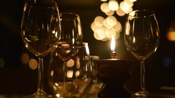 Un tavolo con diversi bicchieri da vino vuoti e una candela.
