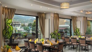 Un restaurant avec de nombreuses tables, des chaises et des plantes en pot.