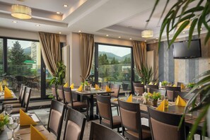 A restaurant with tables set for dining, large windows, and a view of the outdoors. - Sarmis (Deva)