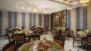 A restaurant with multiple tables, chairs, and hanging lamps. - Sarmis (Deva)