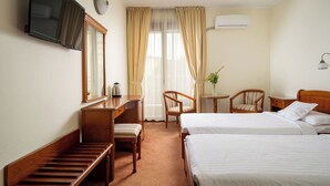 A hotel room with two beds, a desk, a chair, a television, and a window with curtains. - Sarmis (Deva)