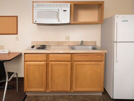 Una cocina compacta con microondas, fregadero y refrigerador.
