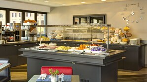 A buffet area with various food items and a clock on the wall. - iQ Hotel Roma (Rome)