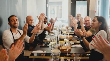A group of people clapping around a table with food and drinks.