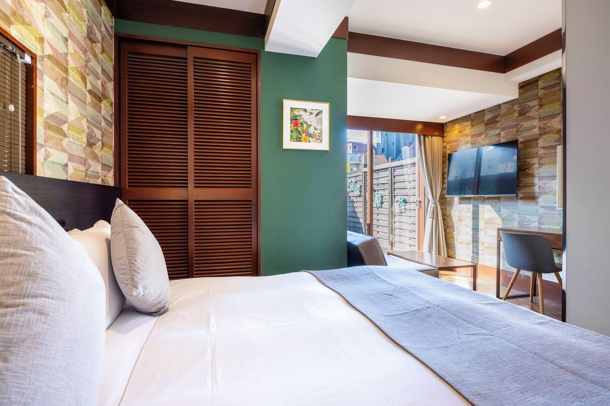 Une chambre d’hôtel moderne avec un grand lit, une télévision et une vue sur la ville.
