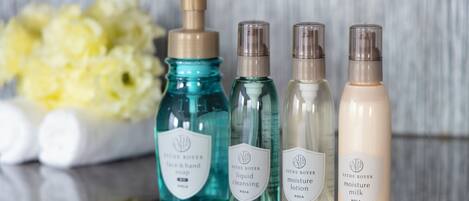 Four bottles of ESTHE ROYER skincare products on a reflective surface.