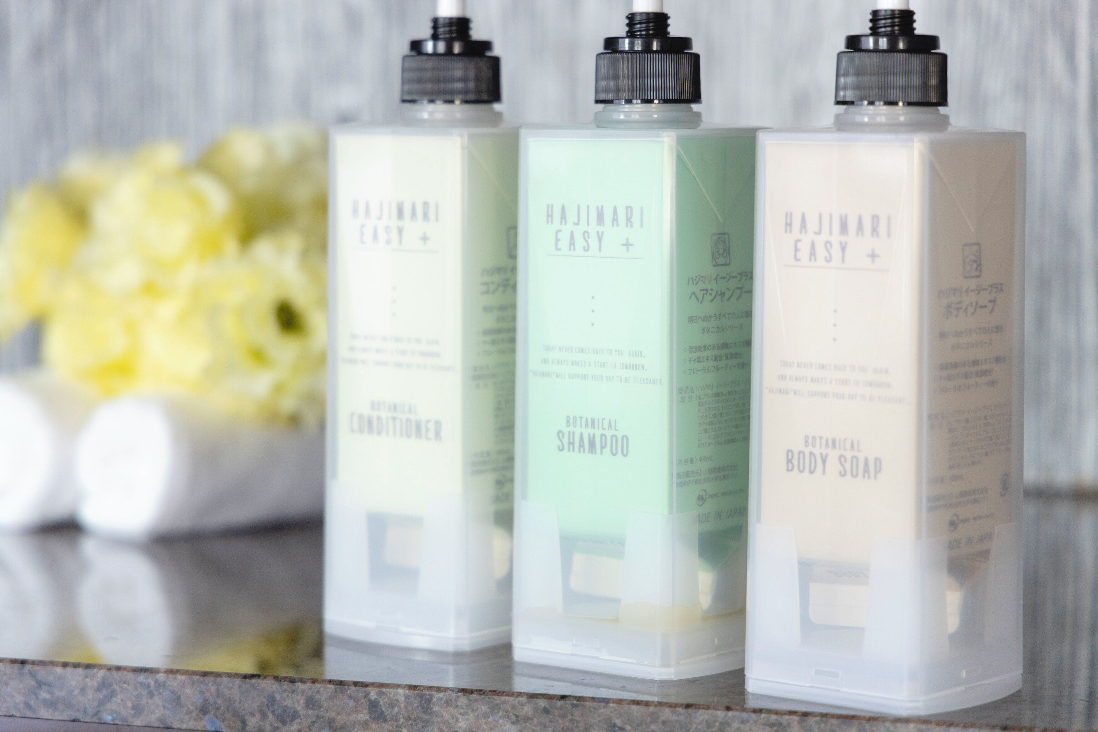Three bottles of Hajimari Easy+ products on a marble surface.