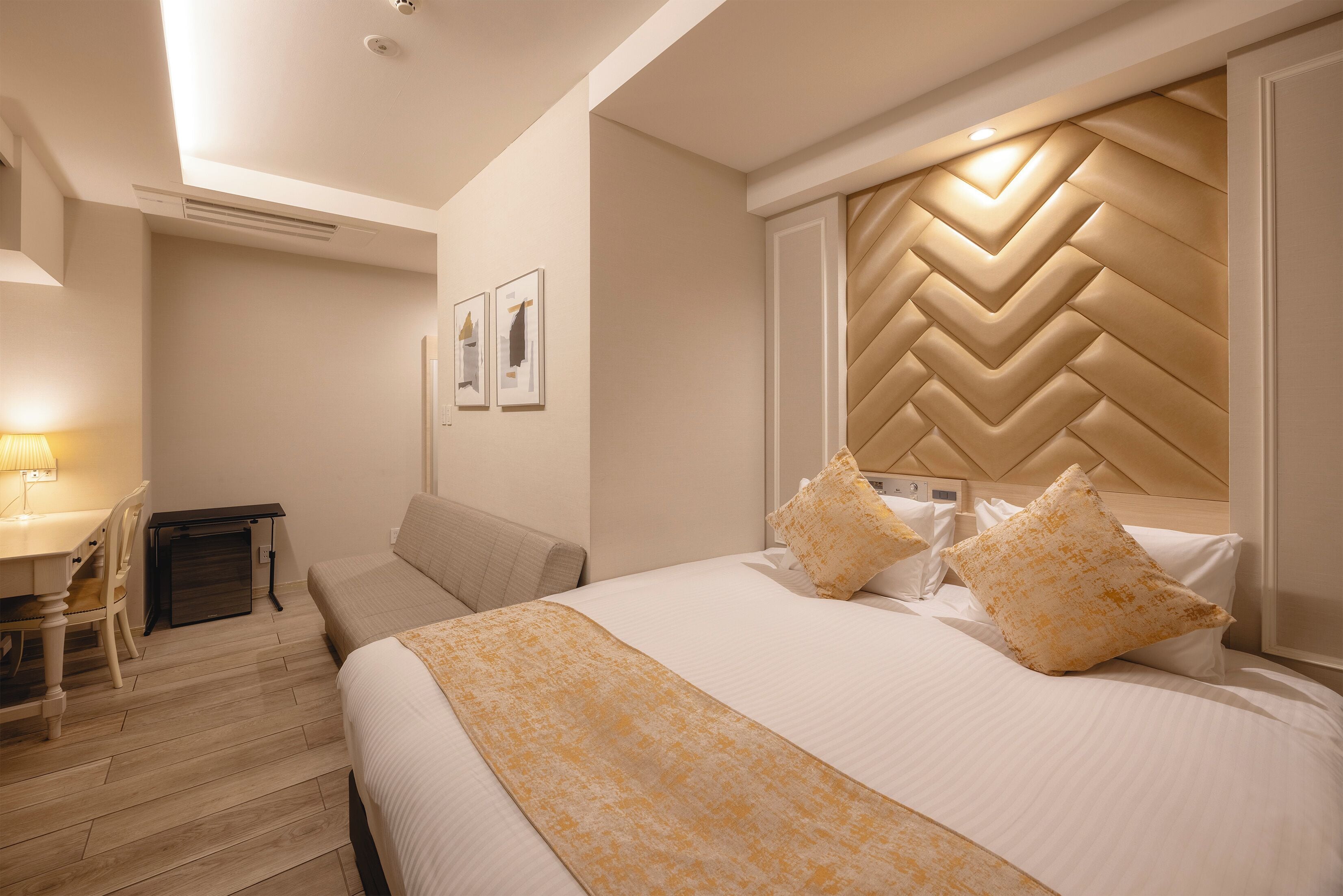 Quarto de hotel com uma cama grande, uma mesa e uma cadeira.