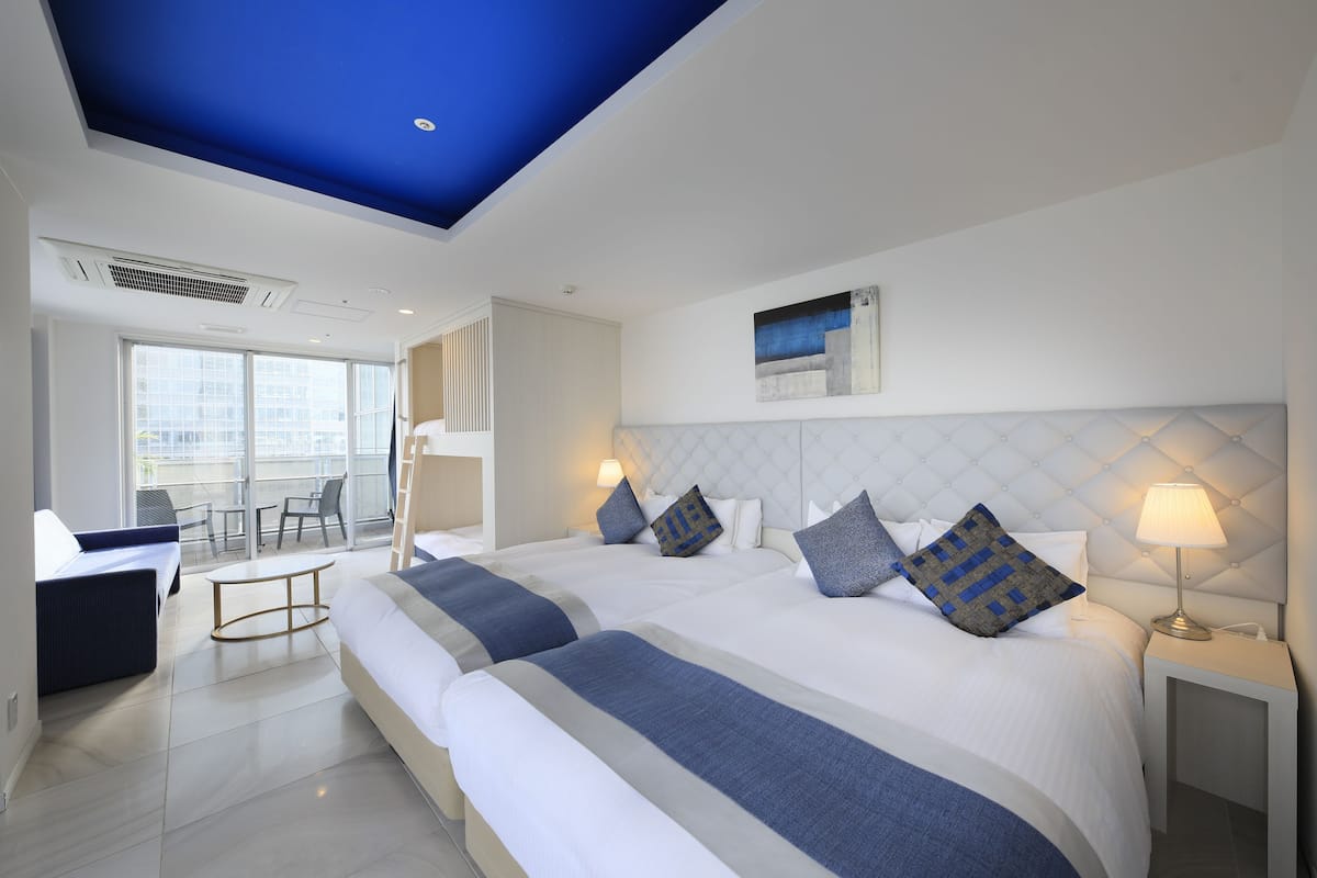 Une chambre d’hôtel avec deux lits, un balcon et un design moderne.