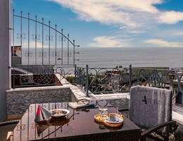 Ein Balkon mit Esstisch, Blick aufs Meer.