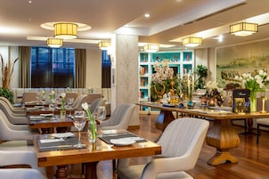 Un comedor con varias mesas dispuestas para comensales, con sillas modernas y una pieza decorativa central.