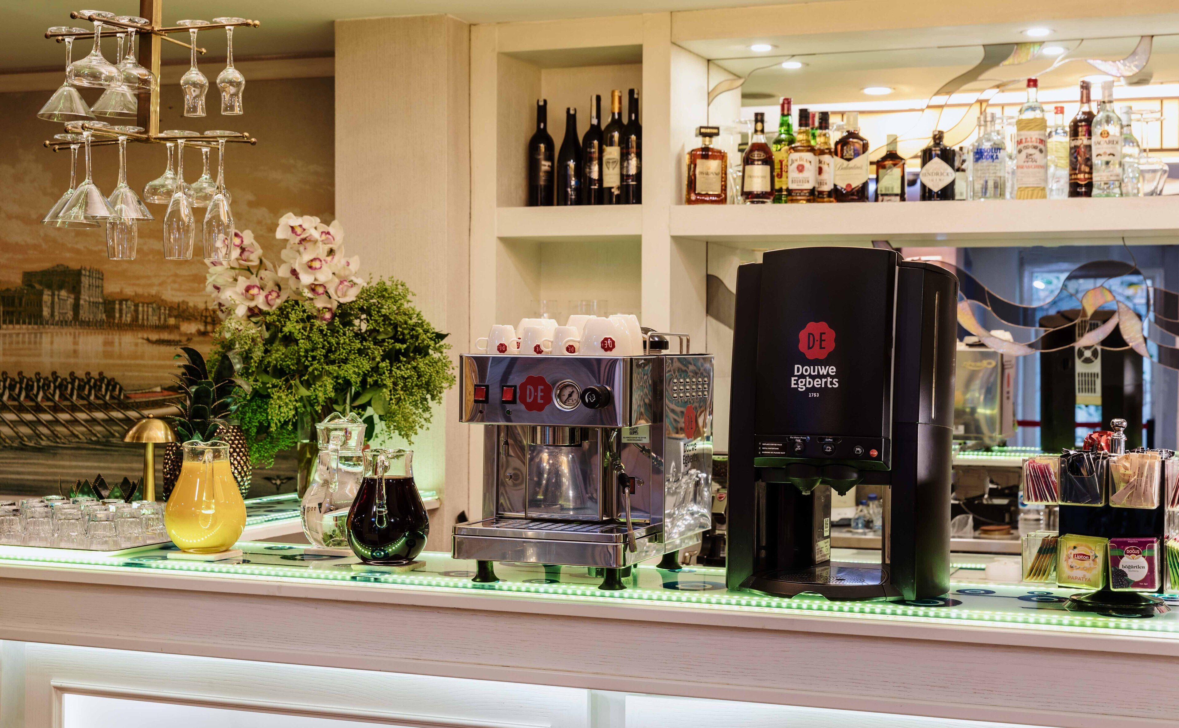 A bar area with a coffee machine, wine bottles, and decorative items.