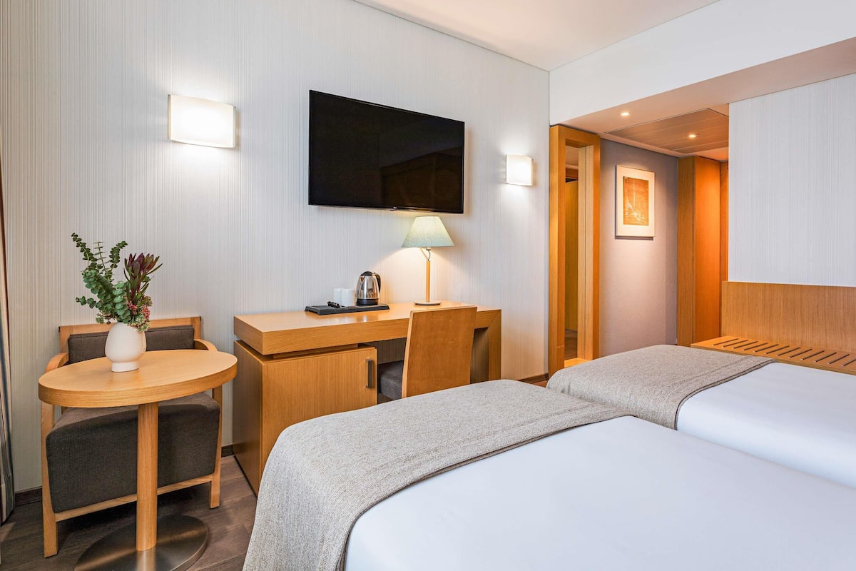 Ropa de cama hipoalergénica y caja de seguridad en la habitación