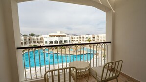 Un balcon donnant sur une piscine et les bâtiments de l’hôtel.