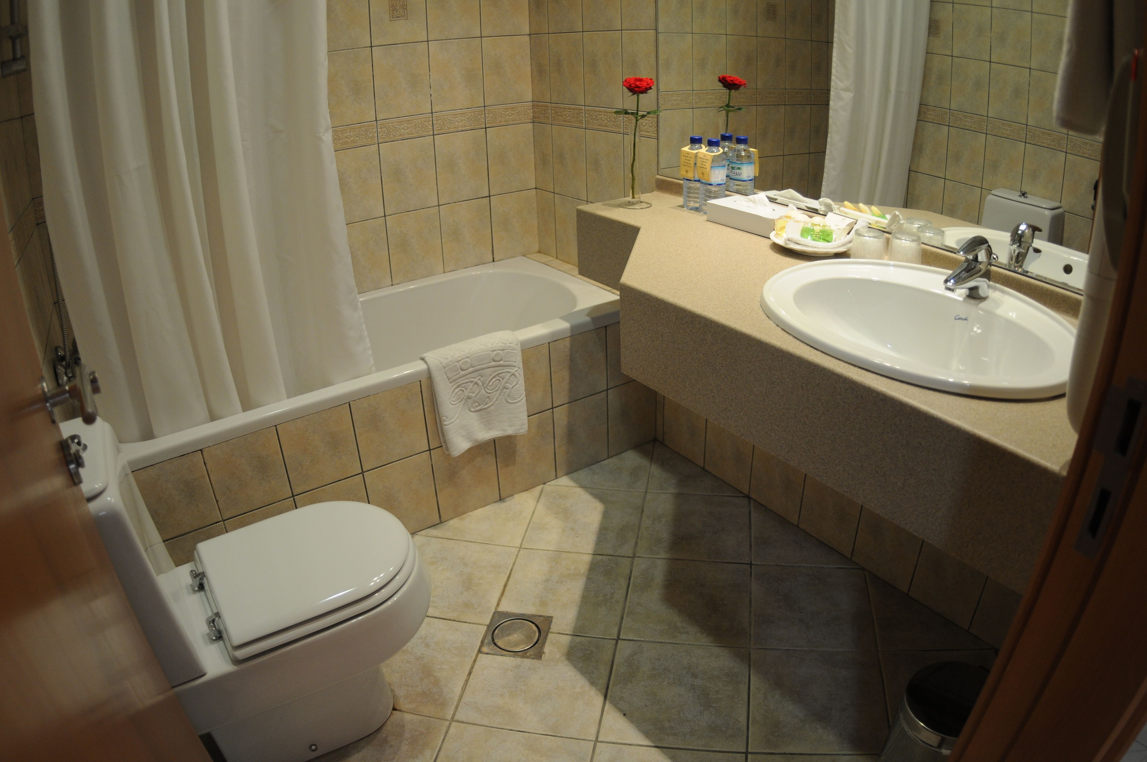 A bathroom with a bathtub, toilet, sink, and vanity.