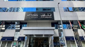 Un hotel de gran altura con varios pisos, ventanas amplias y una entrada destacada con señalización.