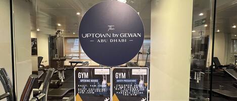 A gym area with exercise equipment and informational signs.