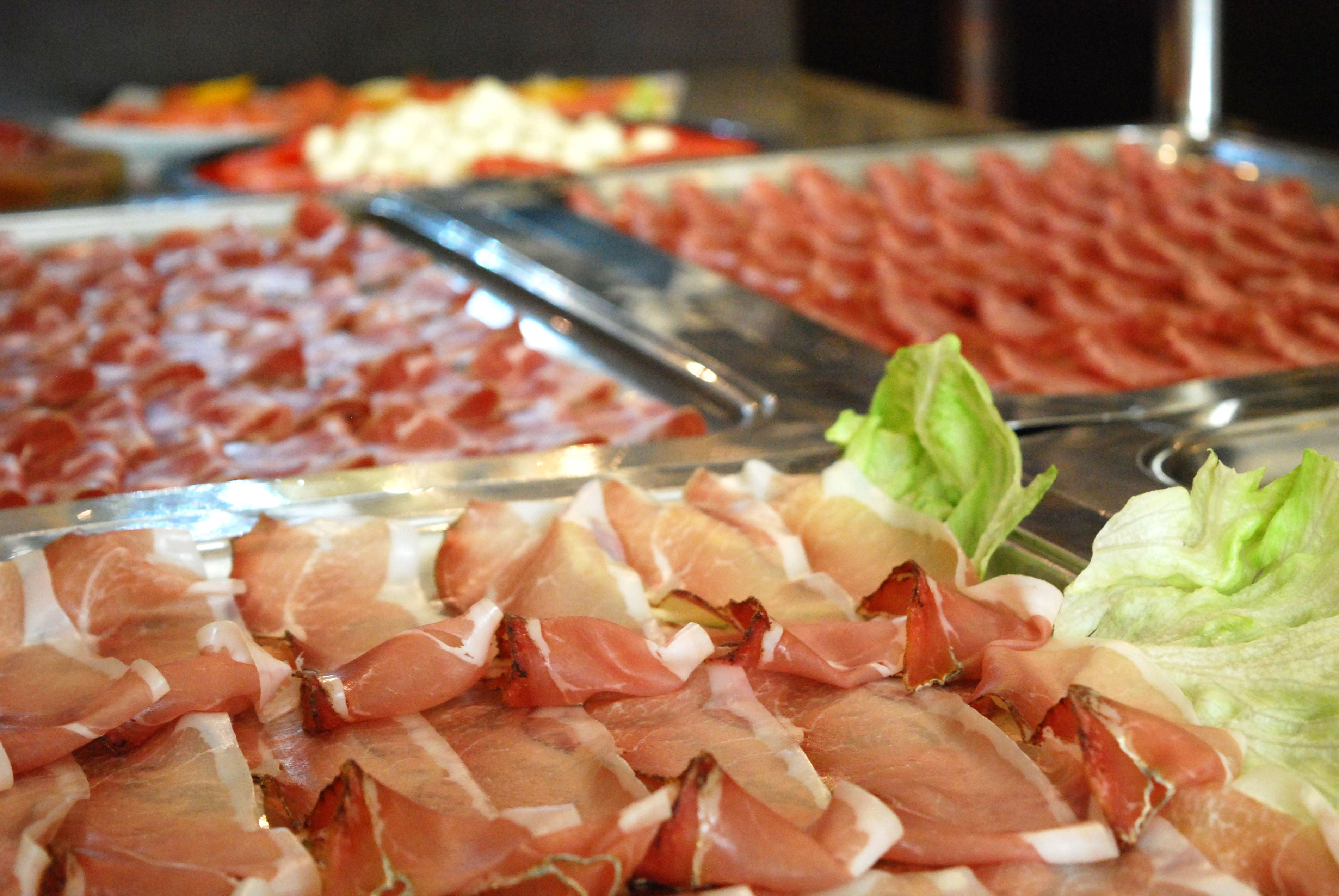 Een buffet met diverse vleessoorten en verse sla.