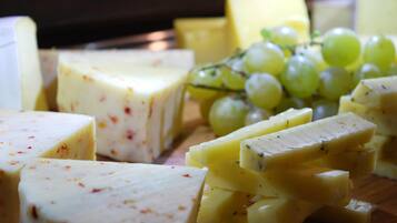A variety of cheeses and grapes on a wooden board.