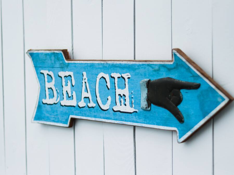 A directional sign with the word "BEACH" and an arrow pointing to the right.