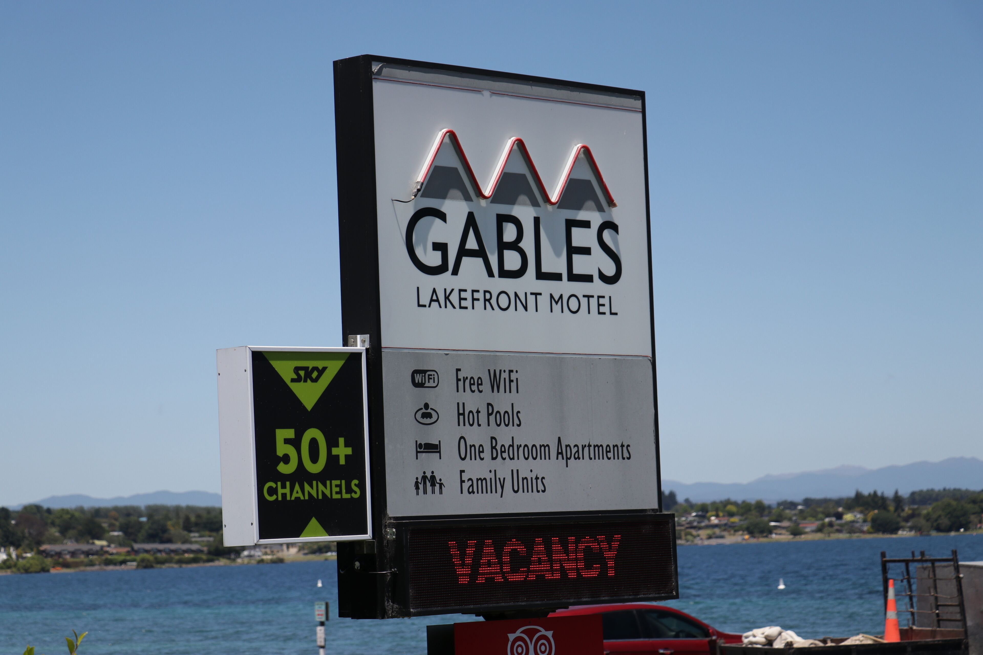 A Gables Lakefront Motel sign with amenities like free WiFi, hot pools, one bedroom apartments, and family units.
