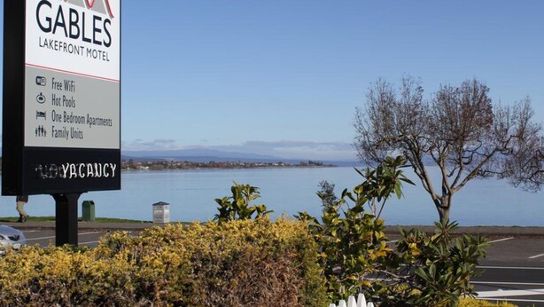 A sign for Gables Lakefront Motel advertising free WiFi, hot pools, one-bedroom apartments, and family units. - Gables Lakefront Motel (Taupo)