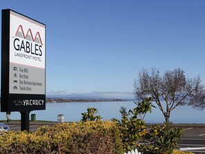 Une enseigne du Gables Lakefront Motel annonce la présence d’une connexion Wi-Fi gratuite, de piscines d’eau chaude, d’appartements d’une chambre et de logements familiaux.