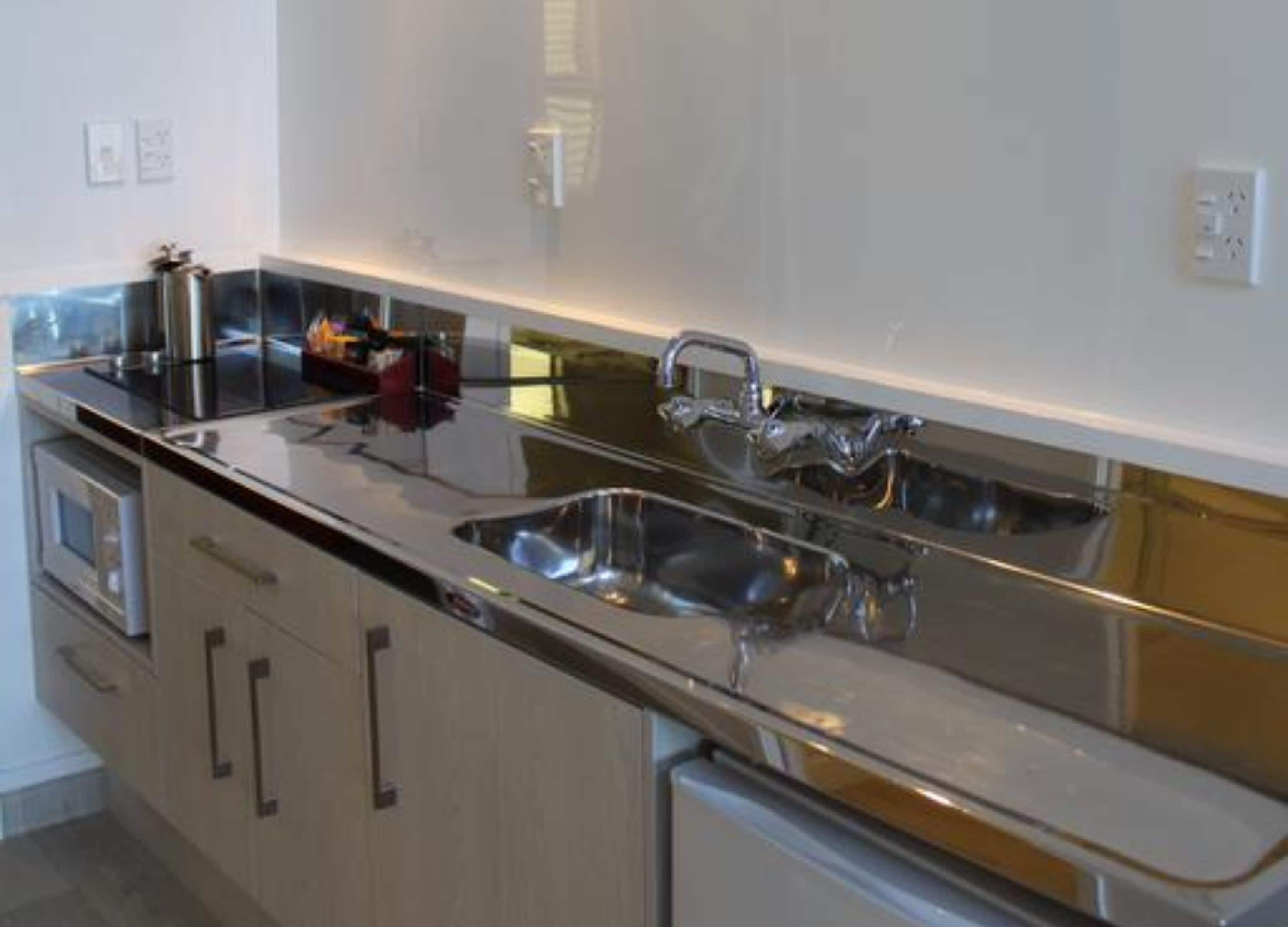 A modern kitchen with stainless steel appliances, a double sink, and a built-in oven.