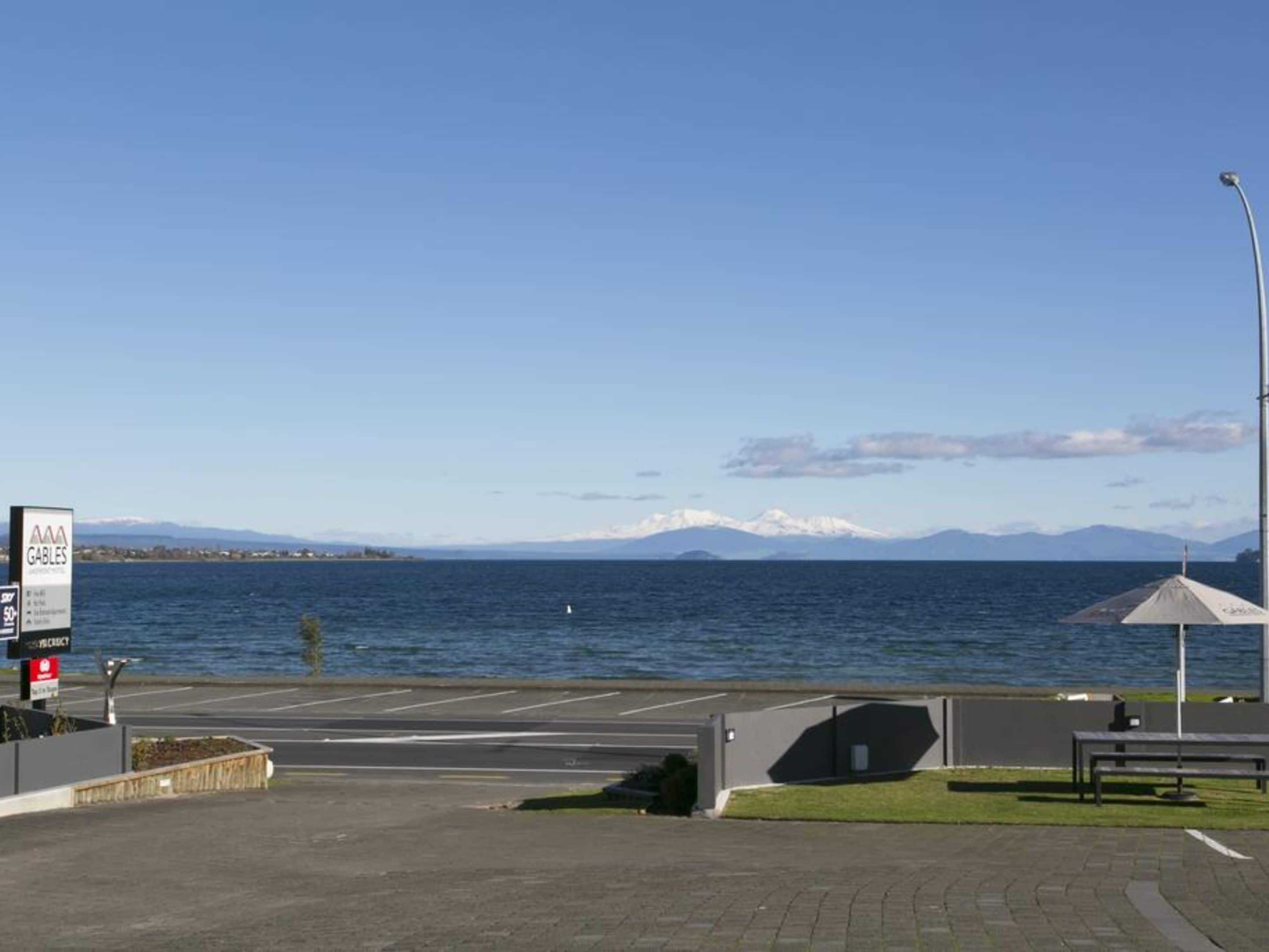 A parking area with a view of the sea and mountains in the background.