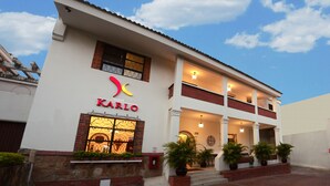 A hotel named KARLO with a white facade, red accents, and a balcony. - Hotel Karlo (Cali)