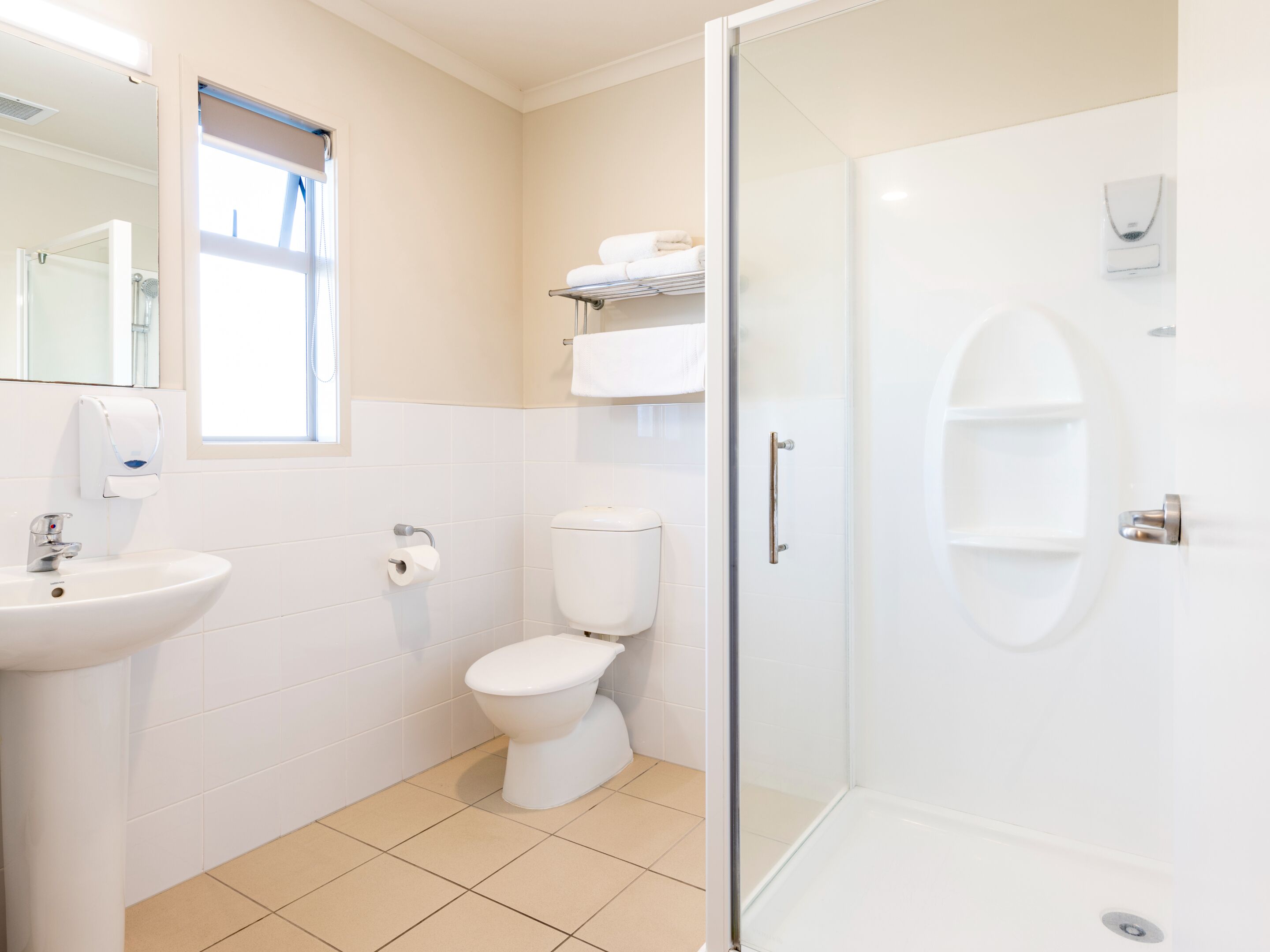 A modern bathroom with a glass shower enclosure, a white sink, and a toilet.