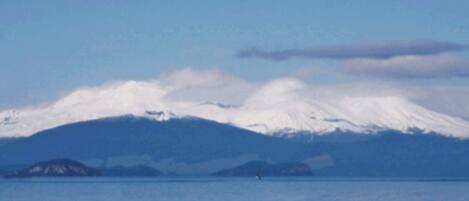 A coastal view with a snow-capped mountain in the background.