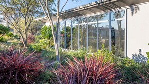 A modern building with large glass windows and a covered outdoor area. - Lake Taupo Motor Inn (Taupo)