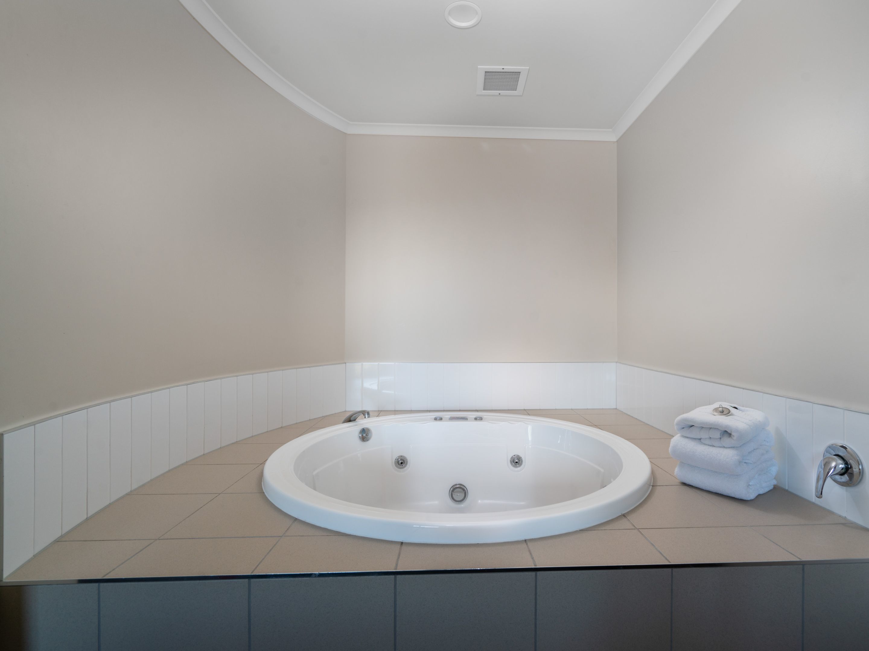 A modern bathroom with a freestanding bathtub, a towel rack, and a toilet.