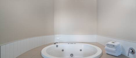 A modern bathroom with a freestanding bathtub, a towel rack, and a toilet.